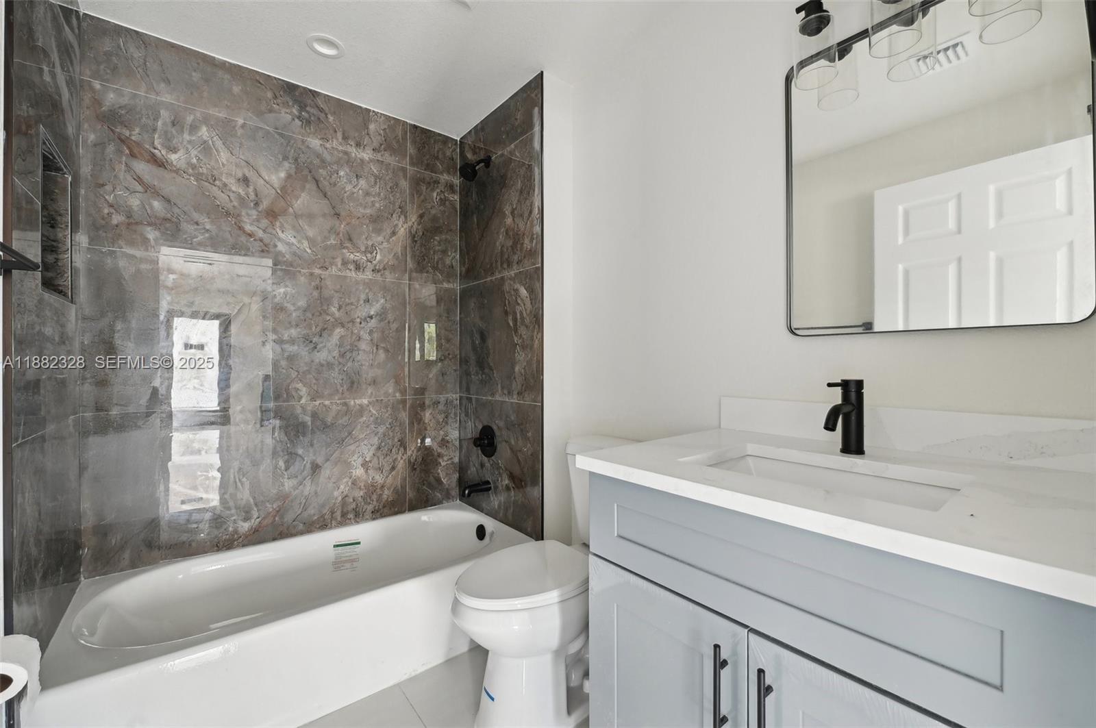 10344 Northwest 29th Avenue, Unit 10344 Miami, FL 33147 - Photo 8 of 12 a bathroom with a sink a toilet and bathtub