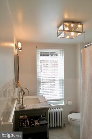 a bathroom with a sink a toilet and a window