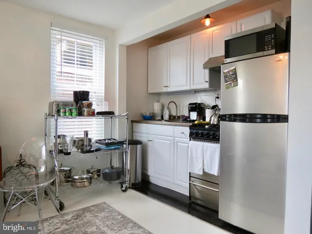 a kitchen with a refrigerator and a stove top oven