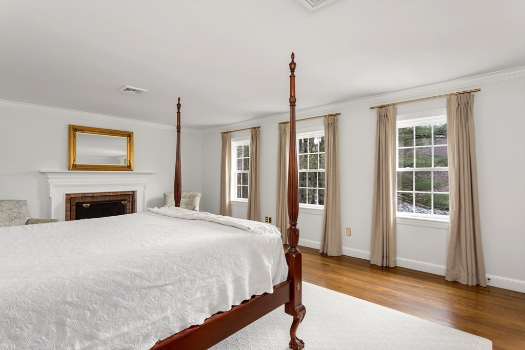 138 Pine Street Dover, MA 02030 - Photo 21 of 38 a spacious bedroom with a bed and a fireplace