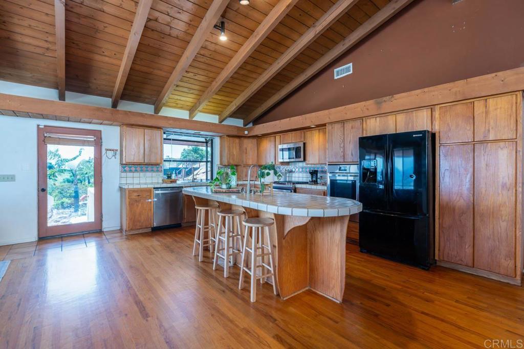 315 Alpine Heights Road Alpine, CA 91901 - Photo 12 of 42 a kitchen with stainless steel appliances granite countertop a refrigerator a sink dishwasher a stove and white countertops with wooden floor
