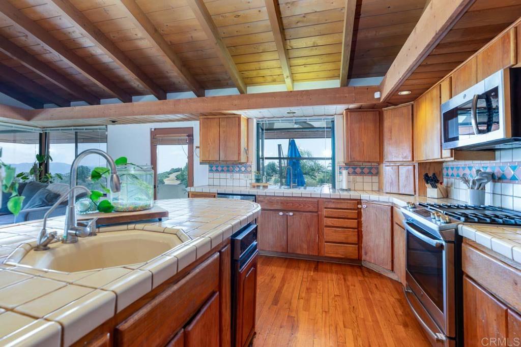 315 Alpine Heights Road Alpine, CA 91901 - Photo 14 of 42 a kitchen with stainless steel appliances granite countertop sink stove and cabinets