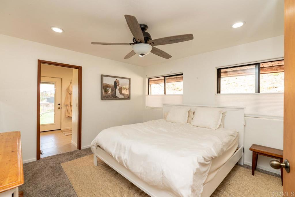 315 Alpine Heights Road Alpine, CA 91901 - Photo 15 of 42 a bedroom with a large bed and a chandelier