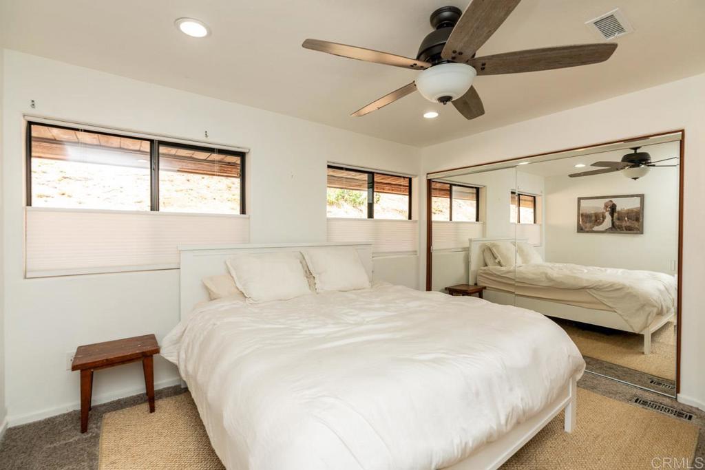 315 Alpine Heights Road Alpine, CA 91901 - Photo 17 of 42 a bedroom with a large bed and a chandelier