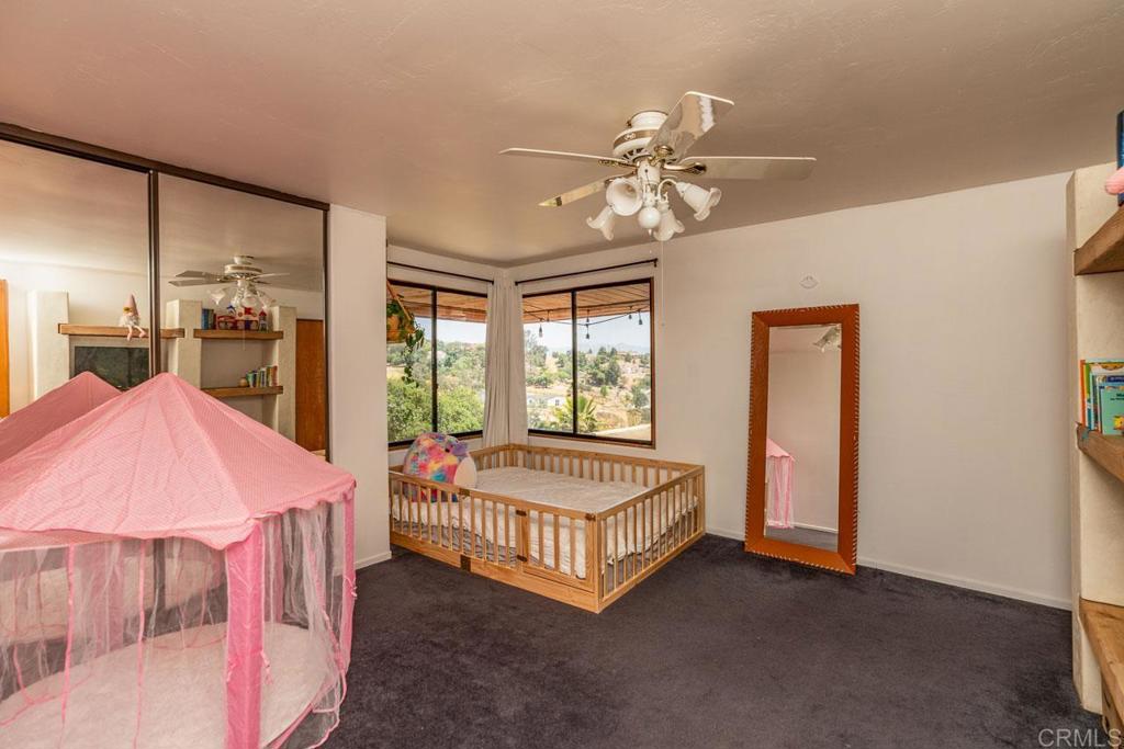 315 Alpine Heights Road Alpine, CA 91901 - Photo 19 of 42 a spacious bedroom with a bed and a chandelier