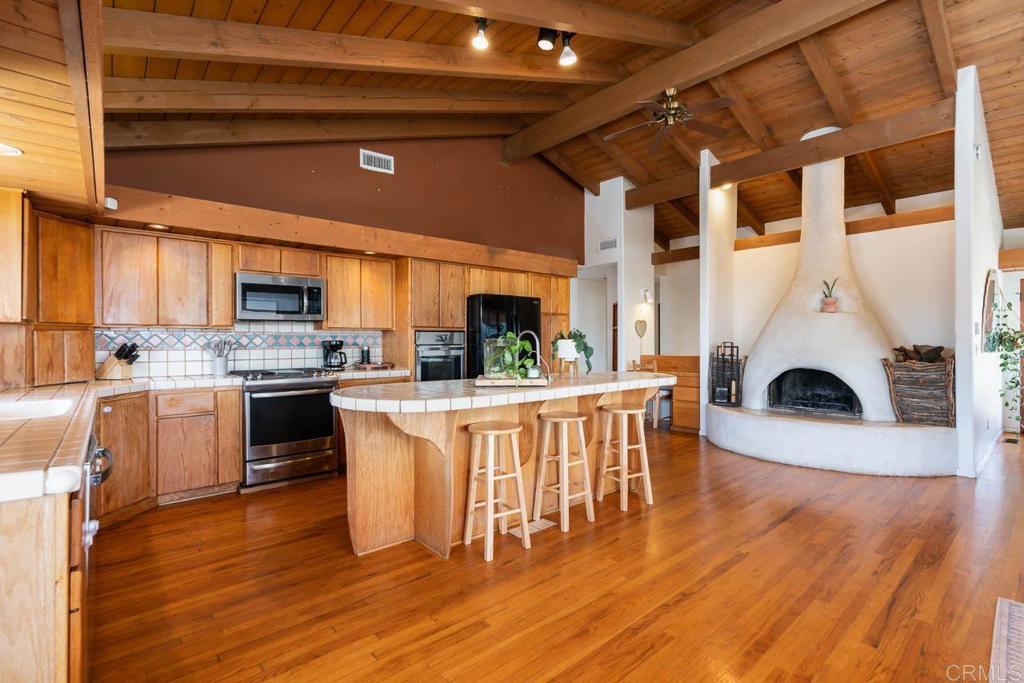 315 Alpine Heights Road Alpine, CA 91901 - Photo 8 of 42 a kitchen with stainless steel appliances granite countertop a stove a sink dishwasher and a refrigerator with wooden floor