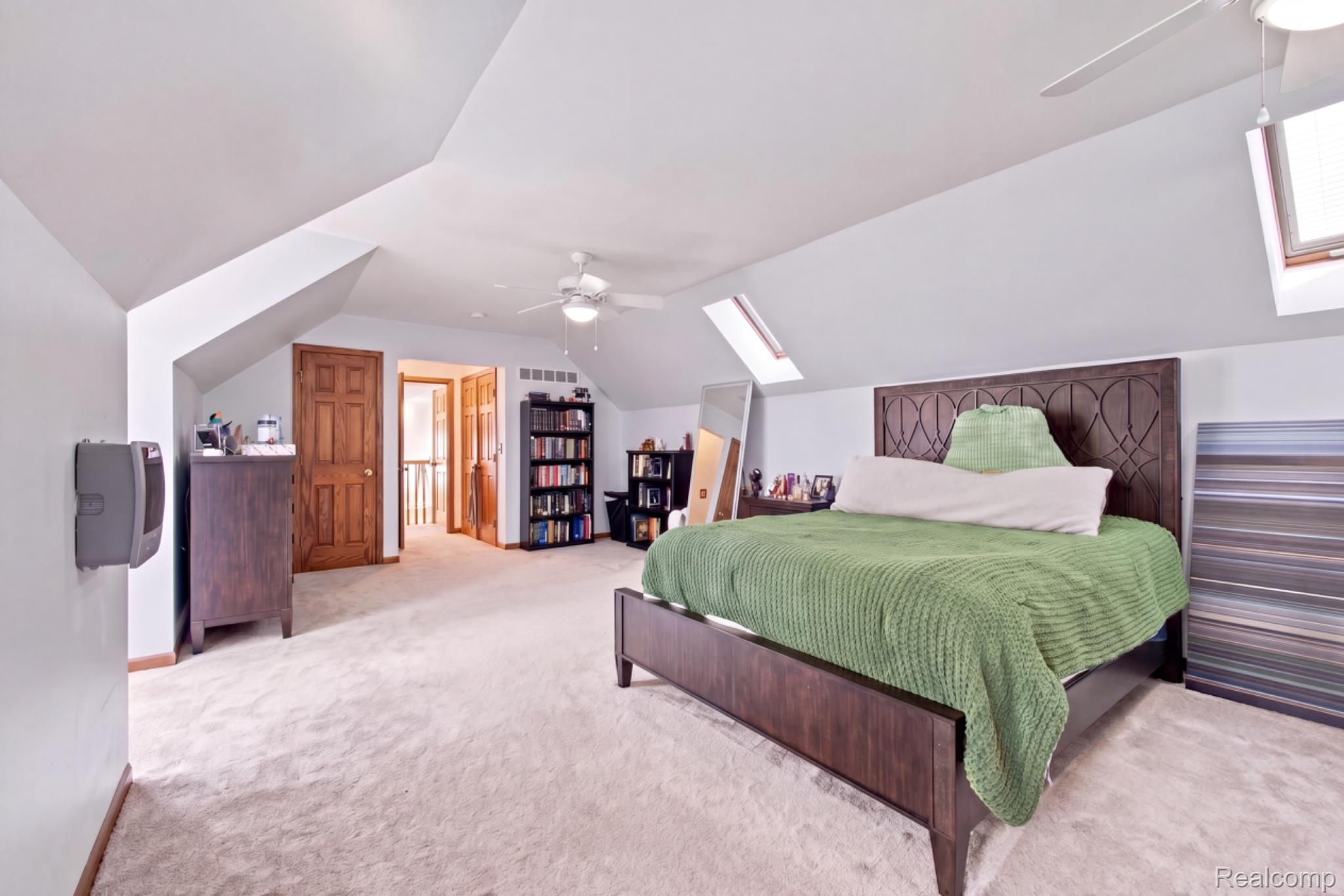 8610 Ferry Road Grosse Ile, MI 48138 - Photo 27 of 55 Carpeted room featuring an angled ceiling, two skylights, a ceiling fan, and wood-finish doors