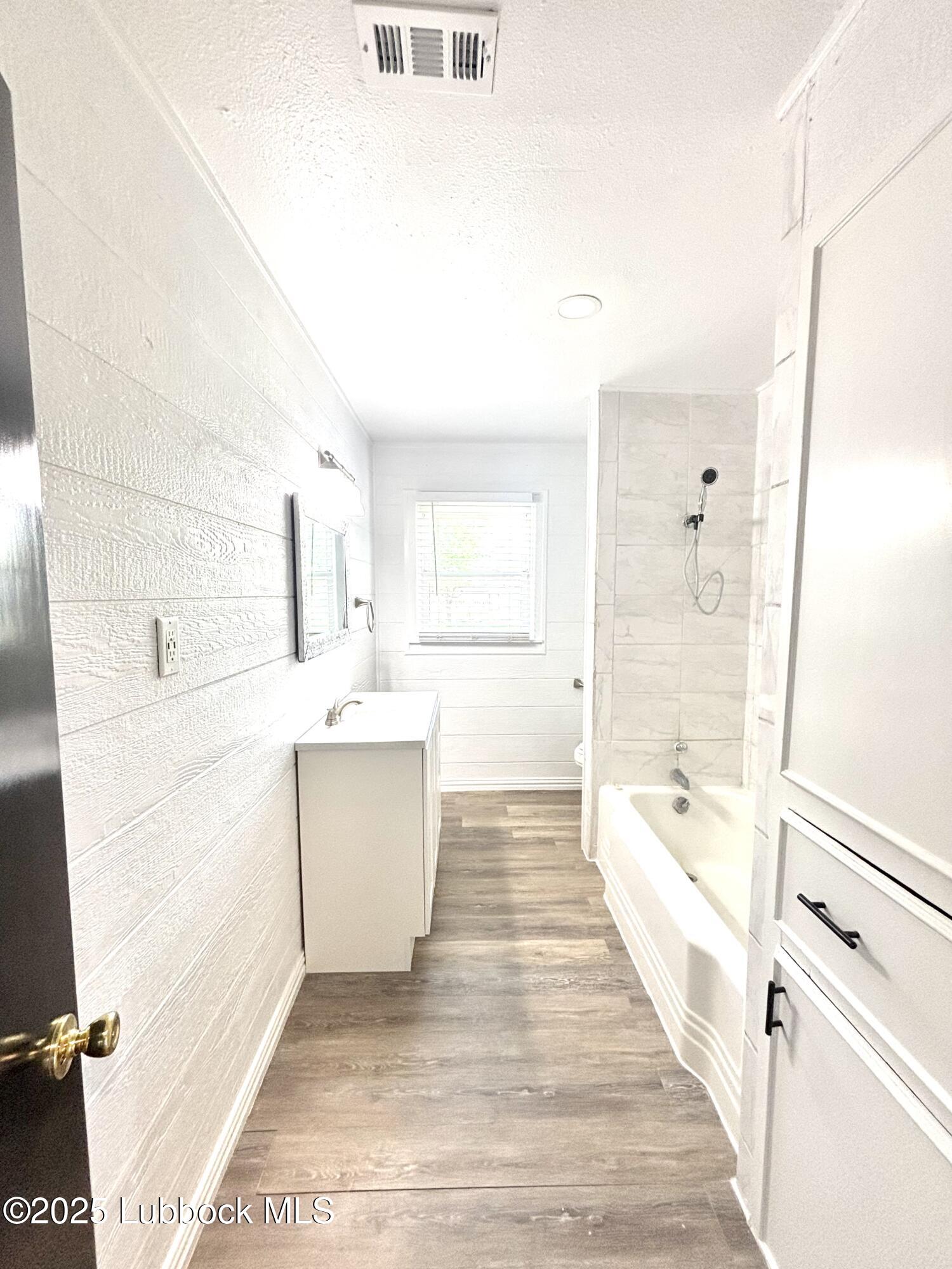815 Amarillo Plainview, TX 79072 - Photo 16 of 17 a bathroom with a sink a mirror and a bathtub