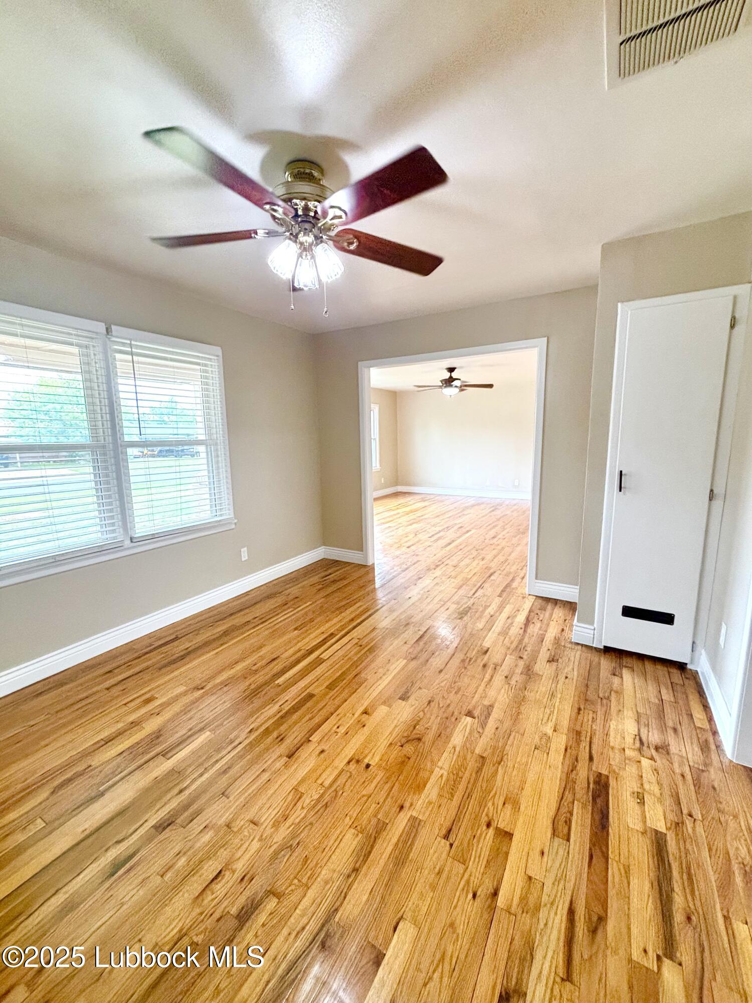 815 Amarillo Plainview, TX 79072 - Photo 5 of 17 a view of an empty room with window and wooden floor