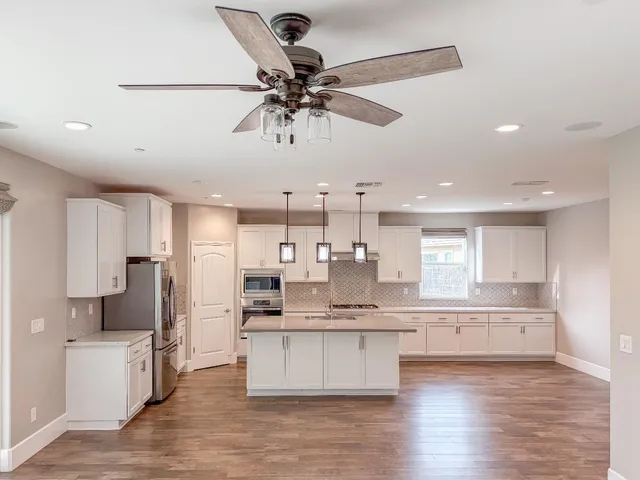 a kitchen with stainless steel appliances granite countertop a stove microwave and sink