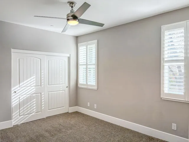 an empty room with windows and closet