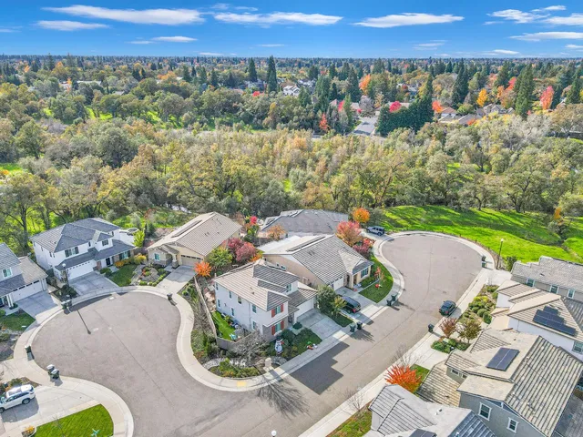 an aerial view of a house with a garden and lake view