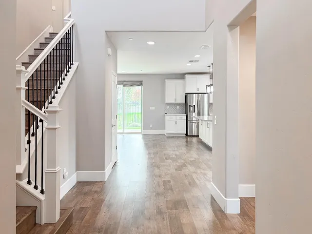 a view of a hallway with wooden floor and staircase