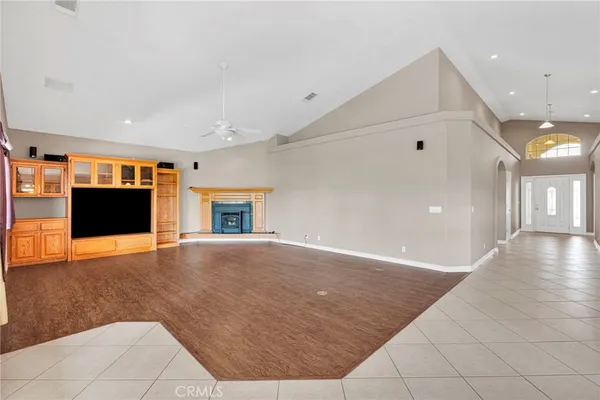 an empty room with windows and fireplace