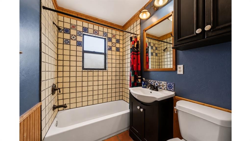 117 Reading Avenue North Center Point, TX 78010 - Photo 17 of 20 Bathroom featuring a tiled shower surround with decorative accents, a white bathtub, and a dark wood-finish vanity with a vessel sink