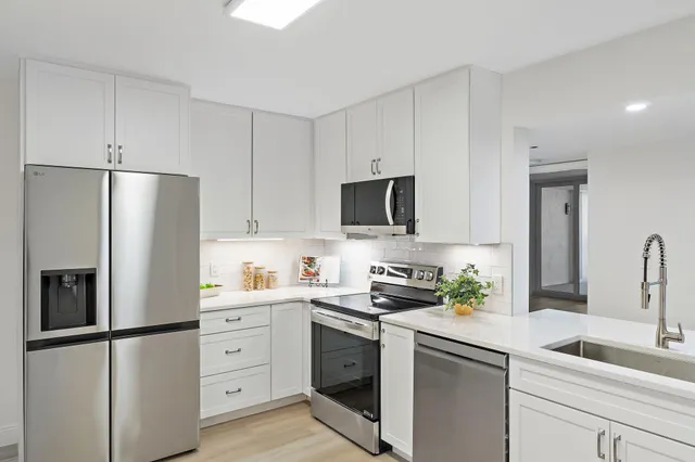 a living room with furniture a flat screen tv and a floor to ceiling window