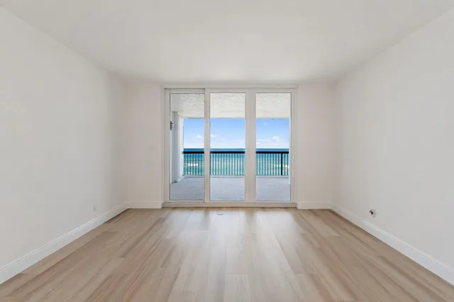 a view of a swimming pool with lawn chairs under an umbrella