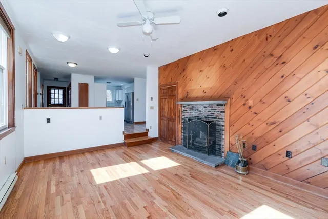 an empty room with wooden floor and fireplace