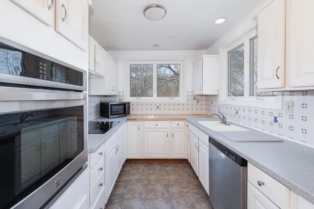 a kitchen with granite countertop a sink stainless steel appliances and cabinets