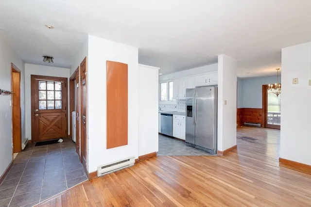 a view of a kitchen with a refrigerator and an empty room