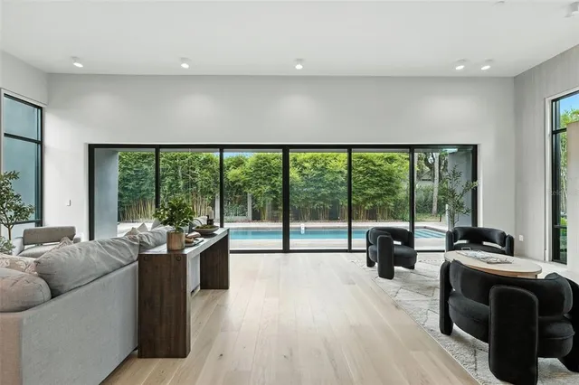 a view of a house with pool fire pit and chairs next to a yard