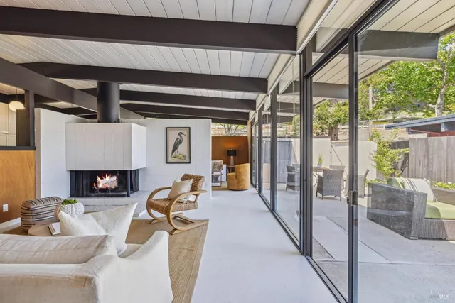 a living room with furniture a large window and potted plants