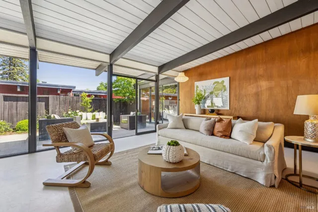 a living room with furniture a wooden floor and a large window
