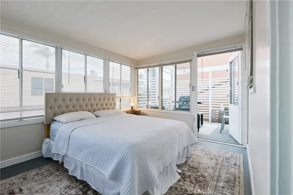 a bedroom with a bed and a large window