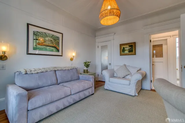 a living room with couches and painting on the wall