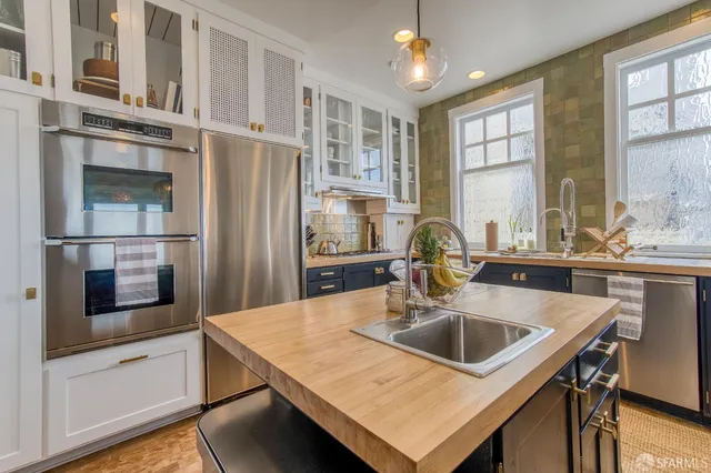 a kitchen with stainless steel appliances a sink and a refrigerator