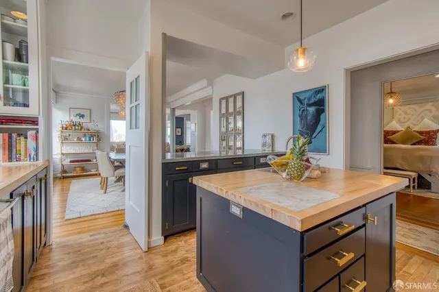 a room with kitchen island a wooden floor and a sink