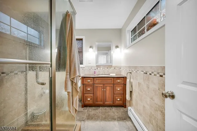 a bathroom with a granite countertop shower sink and mirror