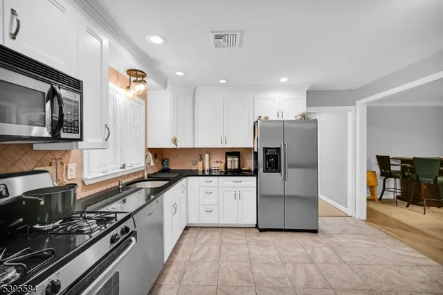 a kitchen with granite countertop a stove and a refrigerator