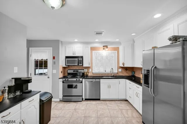a kitchen with stainless steel appliances granite countertop a stove top oven a refrigerator a sink and dishwasher