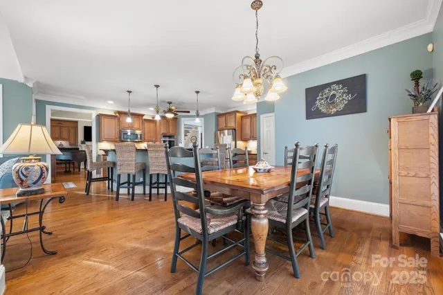 a view of a dining room and livingroom with furniture a rug a rug and a chandelier