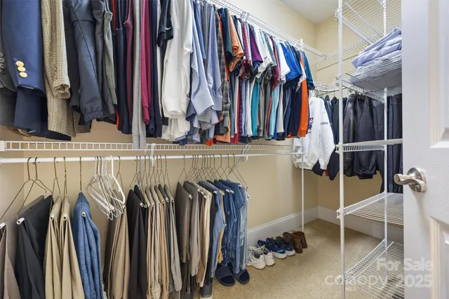 a view of walk in closet with clothes and shoes