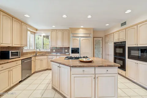 a kitchen with a stove a sink a microwave and cabinets
