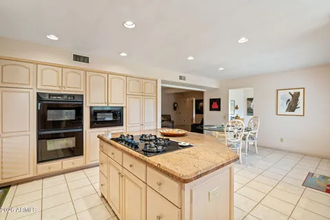 a kitchen with a sink a stove and chairs