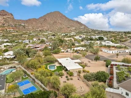 an aerial view of residential houses with outdoor space and trees