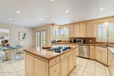 a kitchen with stainless steel appliances kitchen island granite countertop a sink and cabinets