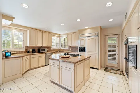 a kitchen with a stove a sink a refrigerator and cabinets