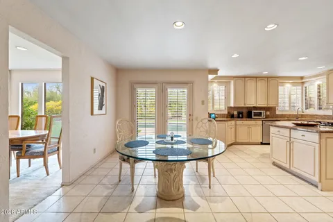 a kitchen with stainless steel appliances granite countertop a stove a sink a refrigerator and a dining table