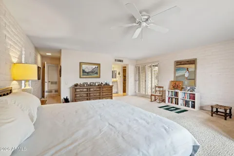 a spacious bedroom with a bed and glass window