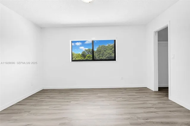 a view of a room with wooden floor and window