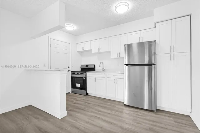 a kitchen with a refrigerator and a stove top oven