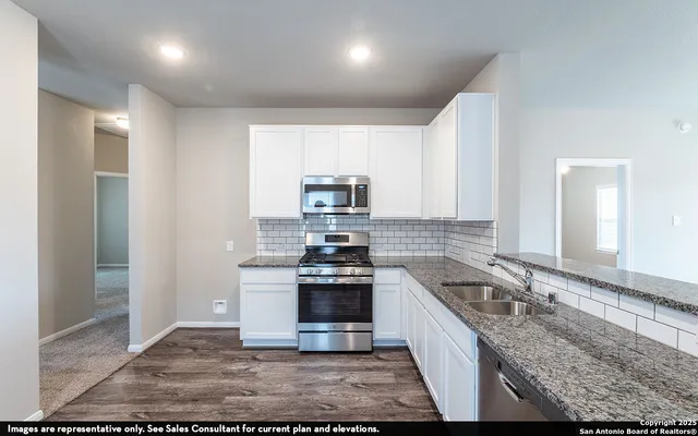 a kitchen with stainless steel appliances granite countertop a stove a sink and a refrigerator
