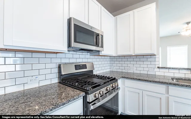 a kitchen with stainless steel appliances granite countertop a sink stove and microwave