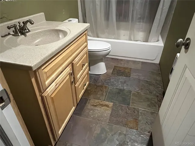 a bathroom with a sink a toilet and shower curtain