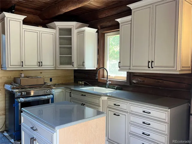 a kitchen with granite countertop a sink and a stove