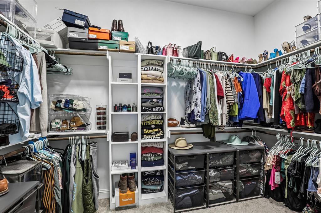 515 West Laureland Road Dallas, TX 75232 - Photo 25 of 32 a view of walk in closet with clothes and shoes